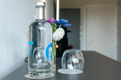 a bottle and a vase with flowers on a counter at Alla Riva in Verona