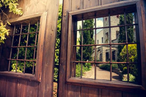 an open window on a building with a reflection of a house at Hotel Villa Venus Resort & SPA in Atena Lucana