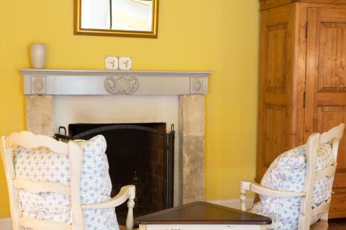 a living room with two chairs and a fireplace at Wedmore Place in Williamsburg