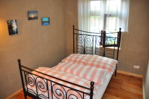 a small bed in a room with a window at Ferienhaus Caselow 23 in Bergholz