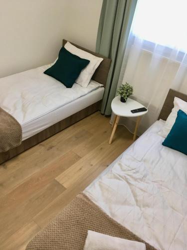 a bedroom with two beds and a table and a window at Apartament 212 in Klikuszowa