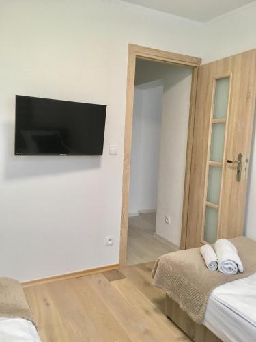 a bedroom with a flat screen tv hanging on the wall at Apartament 212 in Klikuszowa