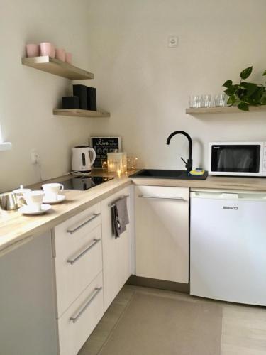 a kitchen with white cabinets and a microwave at Apartament 212 in Klikuszowa
