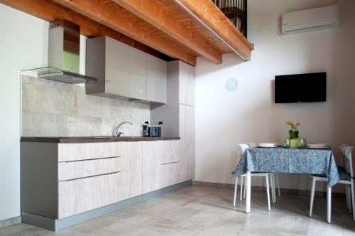 uma cozinha com uma mesa e um lavatório e uma televisão em Corte la Selva em Drugolo
