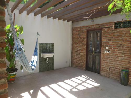 een patio met een hangmat en een bakstenen muur bij Chalés na Hora in Olinda