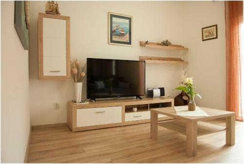- un salon avec une télévision à écran plat dans un centre de divertissement en bois dans l'établissement Admiral, à Kali