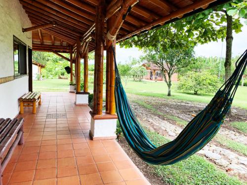 a hammock on a porch of a house at Finca Hotel Santana in Montenegro