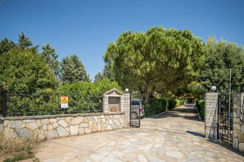 una puerta a una entrada con una valla de piedra en Villa Ampelos en Tesalónica
