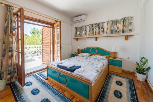 een slaapkamer met een bed en een groot raam bij Villa Ampelos in Thessaloniki