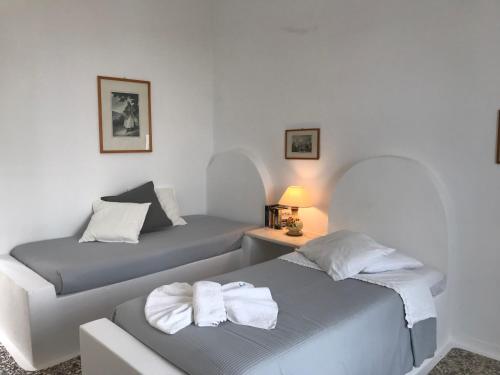 1 dormitorio con 2 camas y toallas. en Bungalows Svoronos, en Naousa