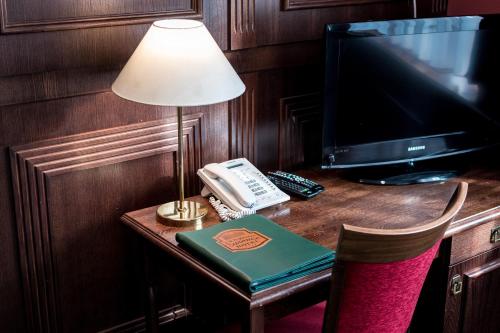 a desk with a phone and a lamp and a telephone at Hotel U Hejtmana Šarovce in Uherské Hradiště