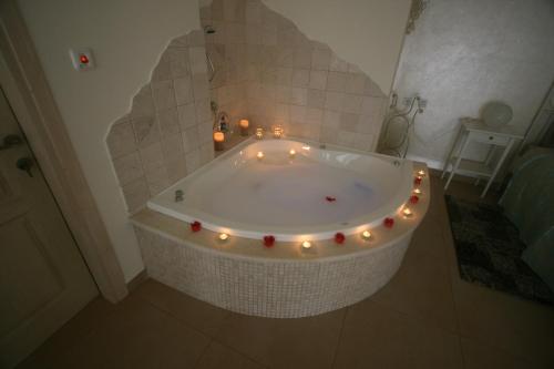 a bathroom with a tub with lights and candles at צימורן in Moran