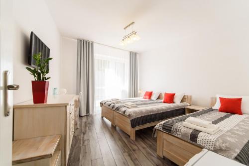 a hotel room with two beds and a television at Ośrodek Wypoczynkowy ,,Relaks-Perła Serpelic'' in Serpelice
