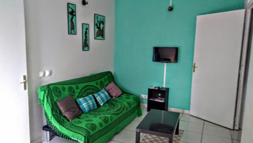a green couch in a living room with a tv at villa siber in Port-Louis