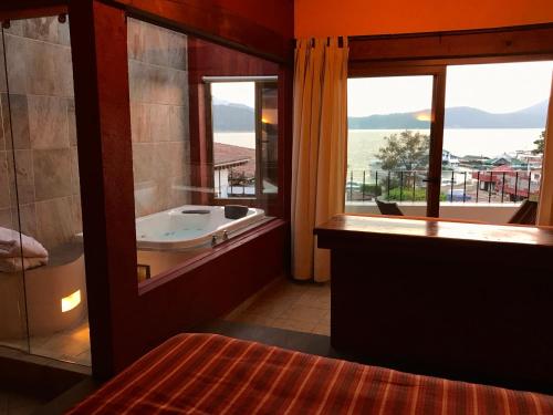a bathroom with a tub and a large window at Hotel puesta del sol in Valle de Bravo