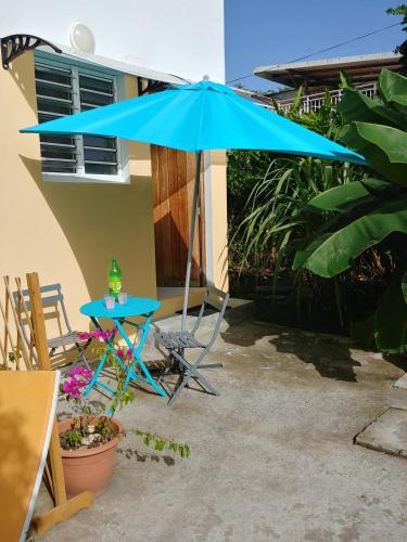 a blue umbrella and a table and a chair at villa siber in Port-Louis
