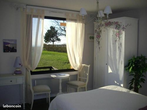 1 dormitorio con cama, ventana, mesa y sillas en villa les falaises, en Berneval-le-Grand