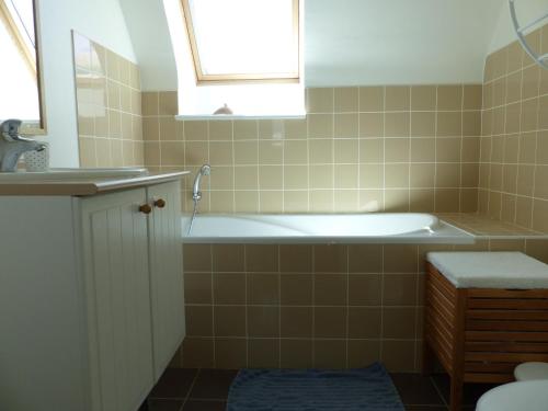 ein Badezimmer mit einer Badewanne und einem Waschbecken in der Unterkunft Ti Moutik in Brignogan-Plage