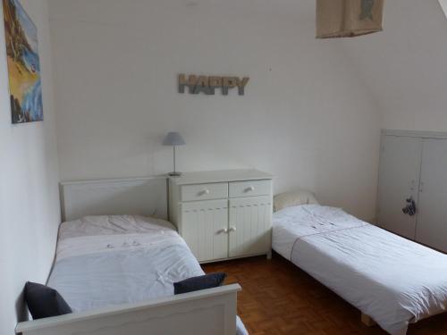 a bedroom with two beds and a dresser in it at Ti Moutik in Brignogan-Plages
