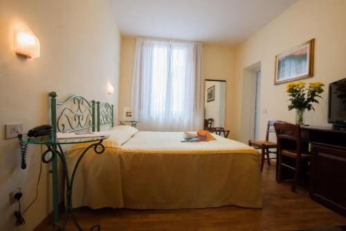 a bedroom with a bed and a window at Hotel Savoia e Campana in Montecatini Terme