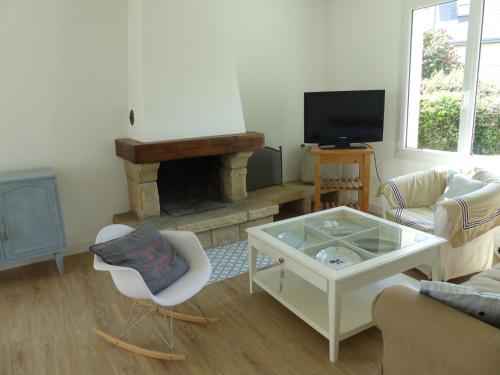 a living room with a coffee table and a fireplace at Ti Moutik in Brignogan-Plages