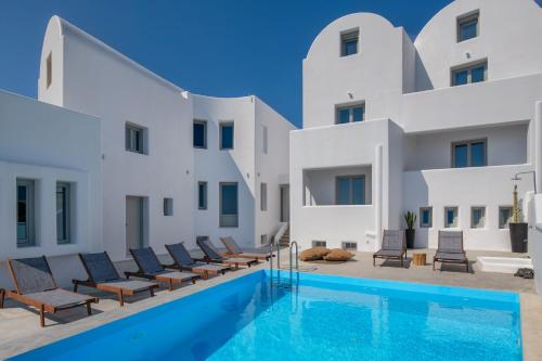 a villa with a swimming pool and white buildings at Seven Suites in Imerovigli