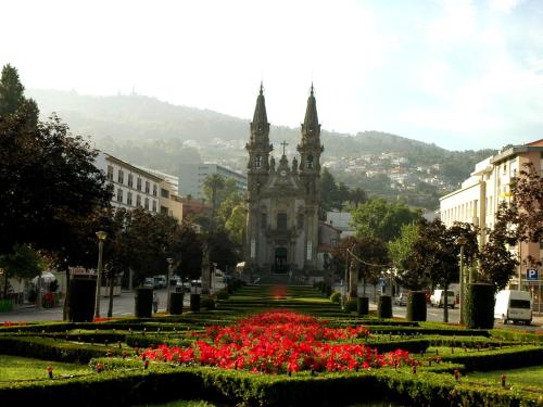 an old building with a bunch of flowers in front at Hotel ibis Guimaraes in Guimarães