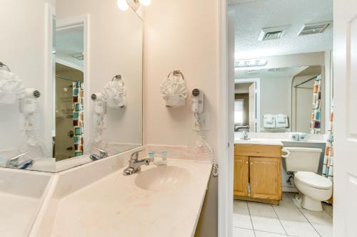 een badkamer met een wastafel, een toilet en een spiegel bij Scenic Views from the balcony at Ocean Forest Plaza Condos in Myrtle Beach