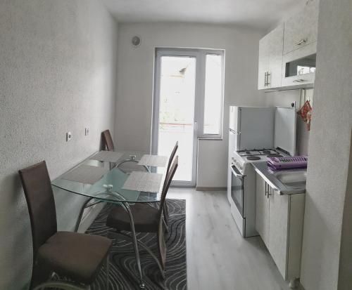 une petite cuisine avec une table et des chaises en verre dans l'établissement Apartment LejlaM, à Sarajevo