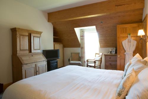 a bedroom with a white bed and a television at Wedmore Place in Williamsburg