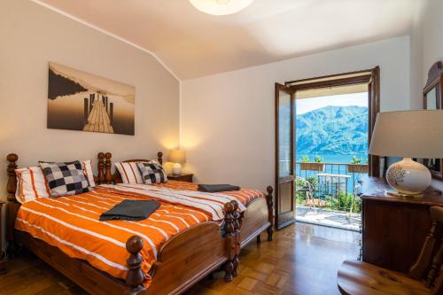 a bedroom with a bed and a large window at Villa Panorama in Oliveto Lario