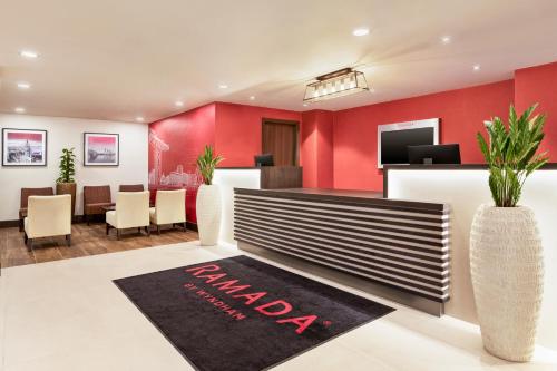 a lobby with red walls and a waiting room at Ramada East Kilbride in East Kilbride