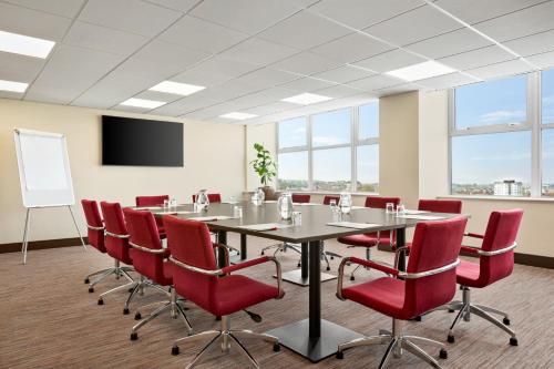 a conference room with a table and chairs and a screen at Ramada East Kilbride in East Kilbride