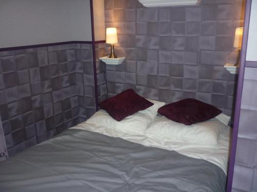 a bed with two pillows on it in a room at Villa Étienne in Le Mont-Dore