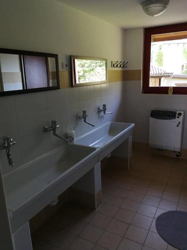 a bathroom with a large tub and a sink at OSTELLO DI SAN GERMANO in Borgofranco dʼIvrea