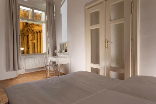 a bedroom with a bed and a window and a chair at Three Golden Crowns Apartments in Prague