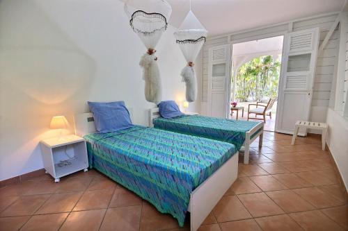 Posteľ alebo postele v izbe v ubytovaní Villa Cattleya 4 chambres, villa avec piscine privée et grande terrasse couverte