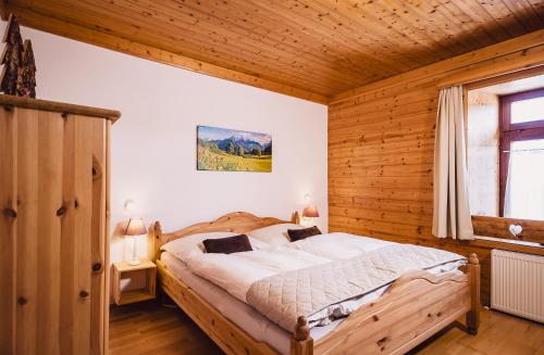 Un dormitorio con una cama en una habitación de madera. en Landhaus Feischl, en Piesendorf