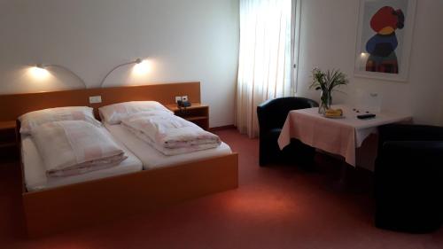 ein Hotelzimmer mit einem Bett und einem Tisch in der Unterkunft Hotel Schlosswald in Triesen