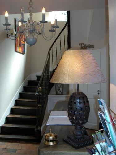 a lamp on a table next to a staircase at Hotel La Closeraie in Sully-sur-Loire