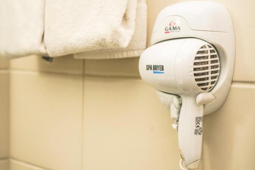 a hair dryer in a bathroom next to a towel at Vitoria Praia Hotel in Vitória