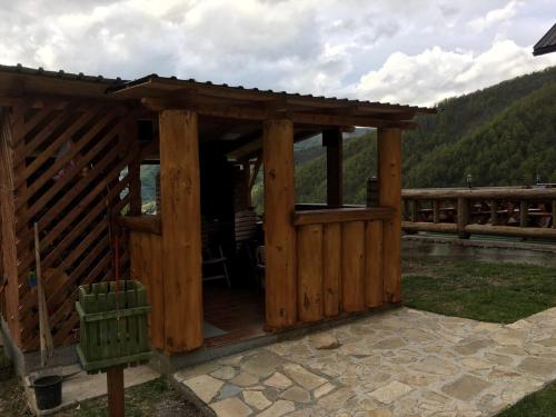 a wooden gazebo on a patio with mountains in the background at Gradine - Katun kamp in Plav