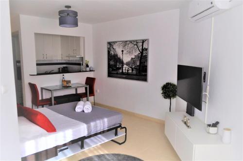 a bedroom with a bed and a table and a kitchen at Studio in The Center of Torremolinos in Torremolinos
