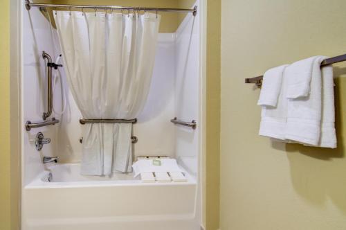 a bathroom with a shower and a tub with a shower curtain at Cobblestone Inn and Suites - Eaton in Eaton