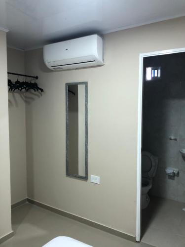 a white bathroom with a mirror and a toilet at Tropical Dreams in San Andrés