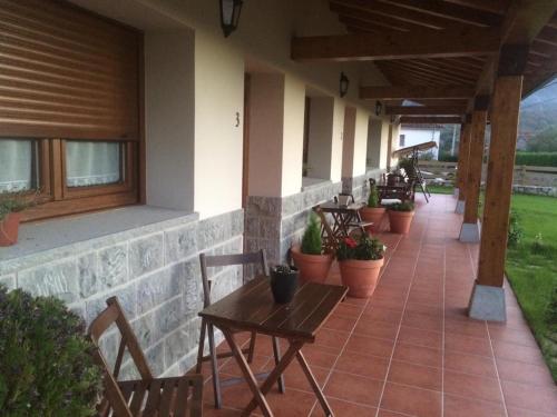a patio with tables and chairs and potted plants at La Llastra de Garaña in Llanes