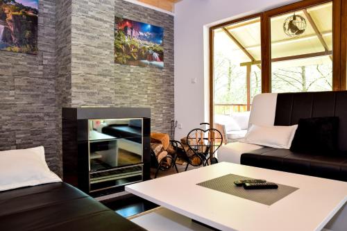 a living room with a couch and a fireplace at Forest Dream Lake House in Jajce