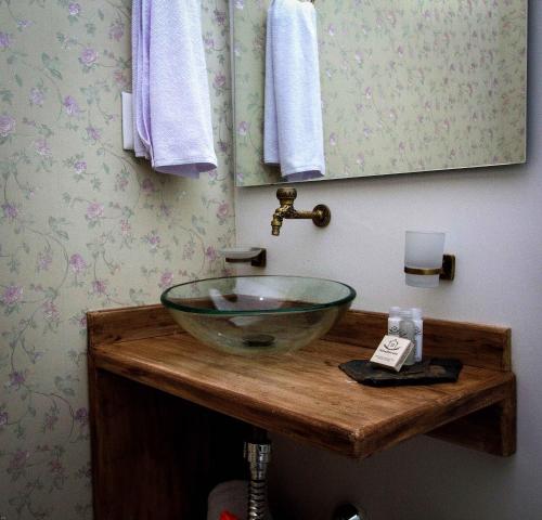 ein Badezimmer mit einem Glaswaschbecken auf einer Holztheke in der Unterkunft Hotel Terra Tacuara in Armenia