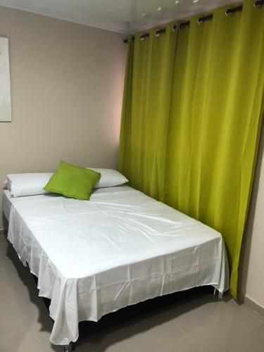 a bed in a room with a green curtain at Tropical Dreams in San Andrés