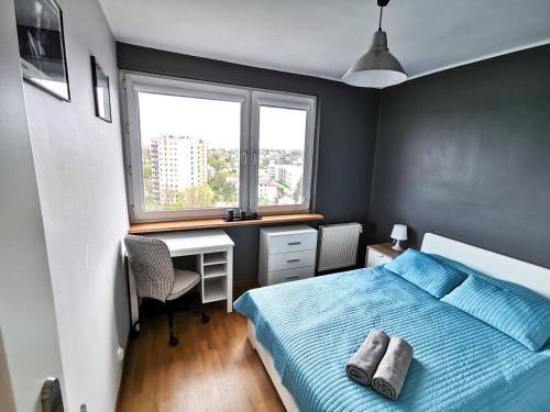 Schlafzimmer mit einem Bett, einem Schreibtisch und einem Fenster in der Unterkunft Sky Apartments - Łagiewniki in Krakau